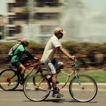 Two cyclists enjoying a sunny ride in Guadalajara, Mexico cityscape.